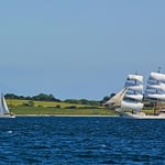 Ostsee Artemis und Segelyacht vor grüner Küste